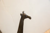Low-angle close-up of the vintage African giraffe's sculpted head and neck.