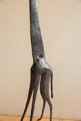 Sculptural detail of the vintage giraffe's torso, showing its dark, pitted surface.