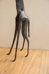 The dark textured surface of the vintage giraffe's slender legs and small tail.