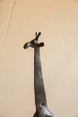 Stylized details of the vintage giraffe's sculpted head, ears, and ossicones.