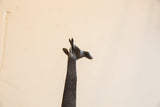 Profile of the dark, textured head of a vintage African giraffe sculpture.