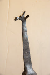 Angled close-up of a vintage giraffe's head and neck showing its dark, textured patina.