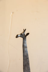 Profile view of the sculpted vintage giraffe head with its smooth finish and textured neck.