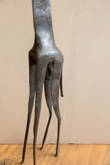 The vintage giraffe sculpture's textured lower body and long, slender legs.