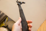 Close-up of the incised pattern and dark matte texture on the vintage giraffe's neck.