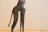 Textured, dark patina on the vintage African giraffe's slender body and legs.