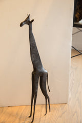 A profile view of the large vintage African giraffe's slender, textured form.