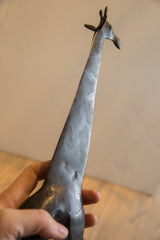 Detailed upward view of the vintage giraffe's textured neck and head.