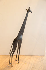 Vintage African giraffe sculpture with an elongated neck and textured dark finish.