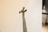 Close-up view of the sculpted head of a vintage African giraffe showing its textured patina.