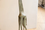 Aged patina and hand-worked texture on the hindquarters of the vintage giraffe sculpture.