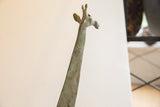Vintage African giraffe sculpture's carved head and long neck viewed from below.