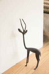 The vintage African gazelle sculpture's slender profile and dark finish.