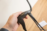 Side view of the vintage gazelle sculpture's dark, patinated body held to demonstrate scale.