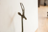Close-up of vintage African gazelle sculpture head with spiral horns and aged bronze patina.