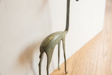 Vintage African gazelle sculpture showing aged greenish patina on its slender legs.