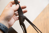Hand holding the dark, textured body and slender legs of the vintage African giraffe.
