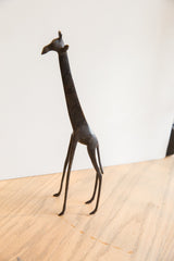 Slender dark legs and lower textured body of the vintage African giraffe sculpture.