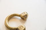 Faceted terminal on an antique Tuareg cuff showing etched motifs and a gold patina.