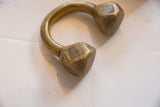 Faceted ends of an antique Tuareg bronze cuff showing engraved details and aged patina.