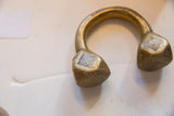 Antique African Tuareg bronze cuff showing its heavy, curved form and etched ends.