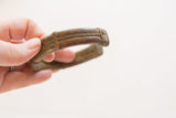 The hand-worked texture and aged patina on the antique African striped cuff bracelet.