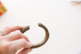 A view of the antique bronze bracelet's open cuff design and rounded ends.