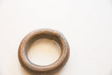 Detail of the join and rustic, patinated surface of the antique copper alloy bracelet.