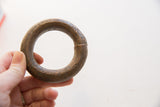 Antique African copper bracelet held to demonstrate its substantial size and textured patina.