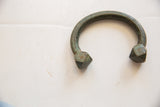 Inscribed pattern and faceted square ends of an antique oxidized copper bracelet.