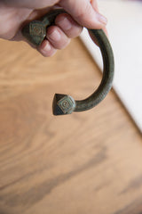 Close-up of the geometric terminals and patterned band of the antique copper cuff.
