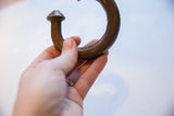 Antique African copper cuff held in hand, detailing its curved form and aged patina.