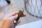 Antique African bronze cuff held to show its substantial form and weathered striped design.