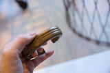 In-hand profile view of an antique bronze cuff showing its raised stripe design.