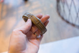 Antique African bronze cuff bracelet held in hand, showing its aged patina and scale.