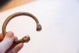 Side view of the antique copper snake cuff revealing its open form and etched details.