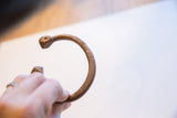 Profile view of the antique African snake cuff showing its curved, textured form.
