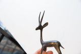 Vintage left facing African gazelle figurine, aged dark metal finish, and slender horns.