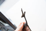 Vintage dark metal African gazelle figurine with aged patina, head and horns held in hand.