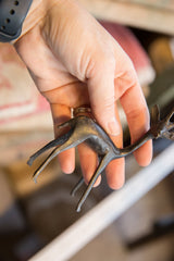 Close-up of the vintage gazelle's slender dark metal legs and aged texture.