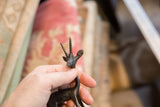 Vintage African gazelle figurine head, featuring textured dark metal and ridged antlers.