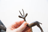 Close-up view of the stylized antlers and head of a vintage African gazelle figurine.