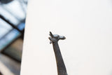 Angled view of the vintage dark bronze giraffe's sculpted head and neck.