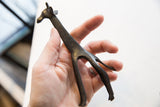 Vintage dark bronze African giraffe held in hand to demonstrate its scale.