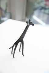 Vintage dark bronze African giraffe figurine shown from a three-quarter view.