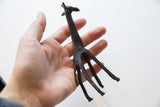 Vintage dark bronze African giraffe, its patterned body texture and slender legs.