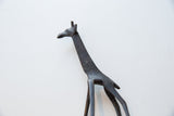 Angled detail view of a vintage bronze giraffe's head and etched neck.