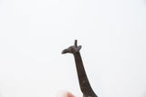 Detailed profile view of a vintage dark bronze giraffe's head and slender neck.