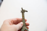 Textured metal with spots of oxidation on the vintage African giraffe collectible.