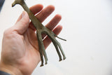 Vintage oxidized African giraffe held to show its slender form and handmade details from below.